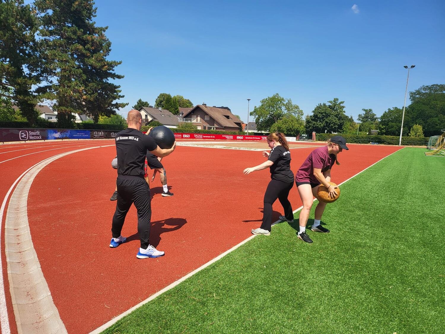Medizinball-Training auf der Laufbahn — Sportlerinnen und Sportler in BSV-Kreuzau-Trikots beim Zuwurf
